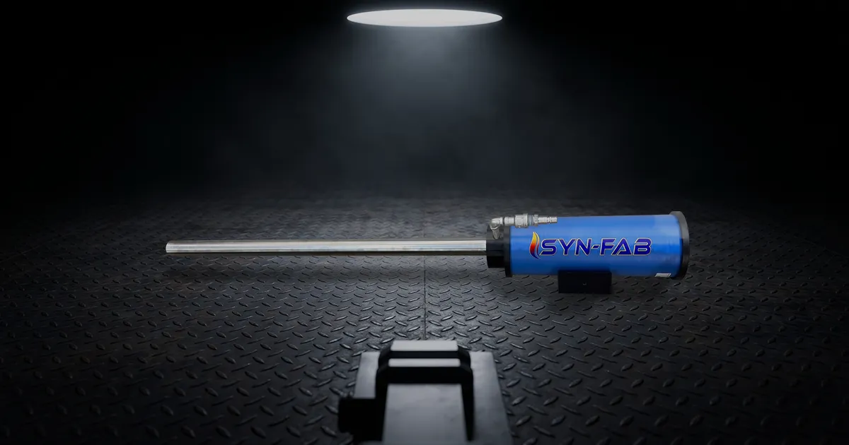 Blue Syn-Fab device with a long metal probe resting on a diamond-plate floor under a single overhead spotlight.